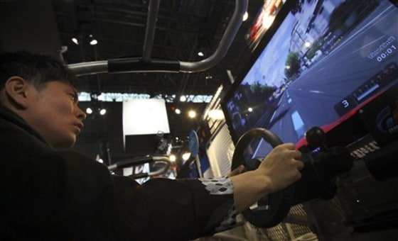 A visitor tries out "Gran Tourismo 5," Sony's new racing simulator game for its PlayStation 3 at the Tokyo Game Show in Makuhari, near Tokyo, Thursday, Sept. 16, 2010. Sony's PlayStation 3 game console will work as a Blu-ray disc player for 3-D movies and music videos, not just 3-D games, with a software update download starting Sept. 21.
